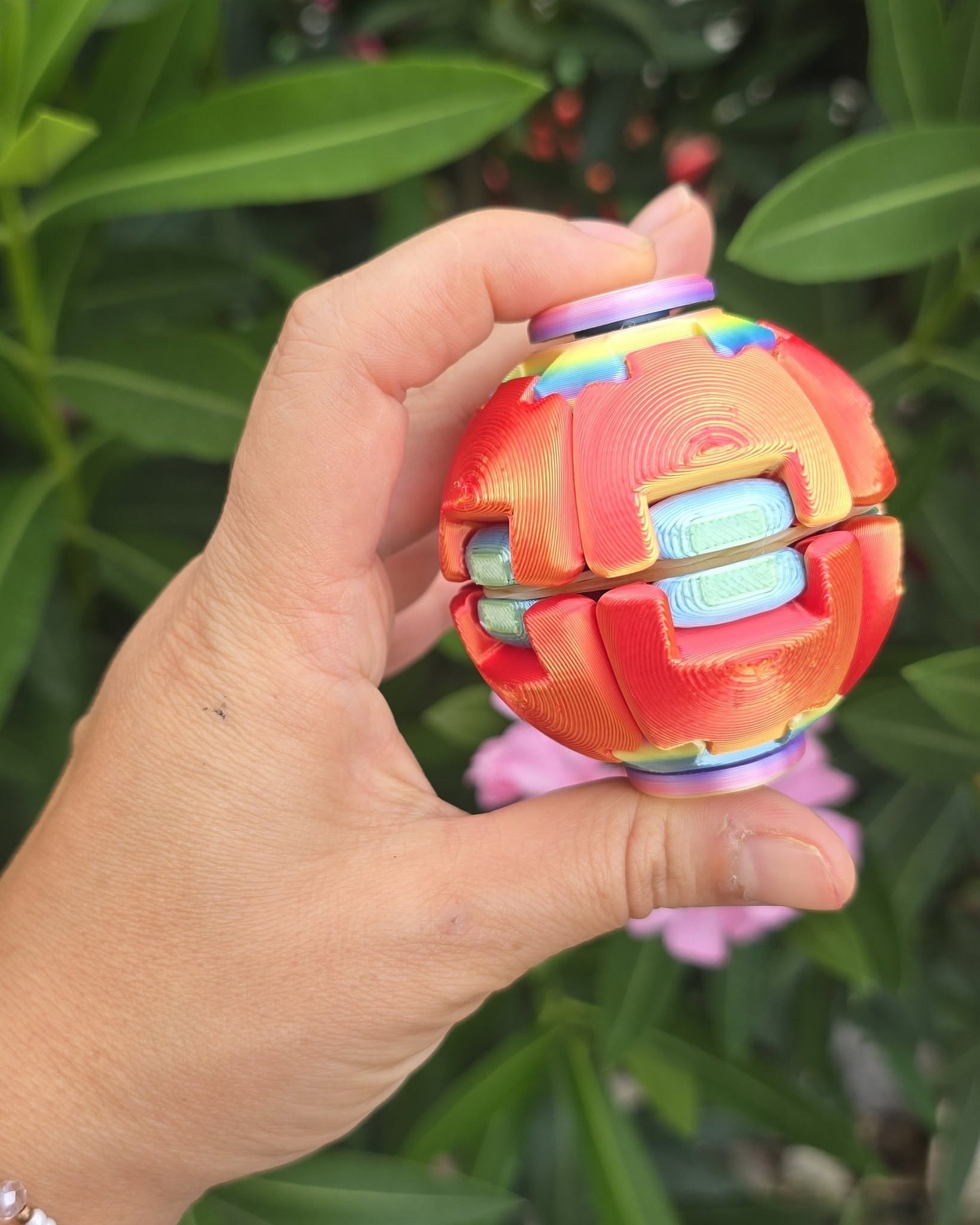 3D Printed Fidget Puzzle Ball – трансформираща се пъзел топка 3D Printed Fidget Puzzle Ball – Антистрес Пъзел Топка е модерна 3D принтирана играчка, която се върти, раздвижва и трансформира само с няколко движения. Сферичната ѝ конструкция е съставена от свързани подвижни части, които детето може да натиска, завърта и пренарежда, докато наблюдава как топката променя формата си. След това елементите могат отново да бъдат върнати в компактната сферична форма. Именно тази комбинация от движение, логика и приятна тактилна игра превръща 3D Printed Fidget Puzzle Ball в интересна антистрес играчка за деца над 8 години, тийнейджъри и възрастни. Многоцветният Rainbow дизайн прави всяка топка още по-забележима. Съчетанието от ярки цветове и видими следи от 3D принтиране придава характерен технологичен вид, който е особено привлекателен за момчета, харесващи механизми, конструктори, пъзели и необичайни Fidget играчки. Защо да купите 3D Printed Fidget Puzzle Ball? Това не е обикновена топка, която детето просто хвърля или търкаля. 3D Printed Fidget Puzzle Ball предлага интерактивно занимание, при което ръцете и вниманието работят едновременно. Детето може да експериментира с различните движения, да открива как са свързани отделните елементи и да търси начин да възстанови първоначалната сферична форма. Играта няма сложни инструкции и може да започне веднага след отварянето на опаковката. Трансформиращата се пъзел топка е подходяща за: занимания у дома; кратки почивки между уроците; пътуване с кола; свободното време в училище; семейни почивки; офис или работно бюро; колекция от 3D принтирани играчки; заснемане на интересни видеоклипове. Натисни, завърти и трансформирай – всяко движение предлага нов начин за игра. Ползи от антистрес пъзел топката за детето Играта с 3D Printed Fidget Puzzle Ball може да насърчи редица полезни умения. Повтарящото се завъртане и преместване на частите ангажира пръстите, дланите и вниманието на детето. Тази Fidget Puzzle Ball подпомага: упражняването на фината моторика; сръчността на пръстите; координацията между очите и ръцете; концентрацията; логическото мислене; пространственото възприятие; търпението; спокойната сензорна игра; откъсването от телефона и екрана. Играчката може да бъде използвана като приятно занимание, когато детето има нужда да държи ръцете си заети. Тя не е медицинско средство, но предлага тактилна и повтаряща се игра, която много деца намират за занимателна и отпускаща. Играчките не правят децата ни по-послушни, но им дават пространство да бъдат себе си, да експериментират, да откриват нови движения и да развиват интересите си. Впечатляваща 3D принтирана играчка за момчета Момчетата, които обичат механични движения, конструктори, трансформиращи се модели и логически предизвикателства, трудно ще останат безразлични към тази играчка. 3D Printed Fidget Puzzle Ball – Антистрес Пъзел Топка изглежда като футуристичен механизъм, скрит в цветна сфера. Различните подвижни елементи могат да бъдат въртени и размествани, което кара детето отново и отново да търси нови комбинации. Няма само един начин за забавление – всяко завъртане променя усещането и формата. Това е прекрасна детска играчка за момче над 8 години, но е подходяща и за момичета, тийнейджъри и възрастни, които харесват Fidget Toys и антистрес занимания. Rainbow Fidget Ball от PLA материал 3D Printed Fidget Puzzle Ball е изработена чрез технология за 3D принтиране от PLA. Върху опаковката материалът е обозначен като биоразградим. PLA се използва широко при изработката на 3D модели, декоративни предмети и играчки. Характерните пластове от процеса на 3D принтиране са част от дизайна и не трябва да бъдат приемани като дефект. Те придават на всяка топка оригинална текстура и технологична визия. Многоцветните Rainbow варианти могат да се различават според начина, по който цветовете са разпределени при принтирането. Това означава, че всяка 3D Printed Fidget Toy може да има своя уникална цветова комбинация. Оригинален подарък за момче над 8 години Търсите подарък, който да не остане забравен веднага след отварянето? Трансформиращата се 3D Printed Fidget Puzzle Ball е чудесен избор за дете, което харесва пъзели, механизми и модерни антистрес играчки. Подходяща е като: подарък за 8-годишно момче; подарък за 9-годишно момче; подарък за 10-годишно момче; подарък за 11 или 12-годишно дете; подарък за тийнейджър; подарък за рожден ден; подарък за Великден; коледен подарък; изненада за успешно завършване на учебната година; награда за добро представяне; подарък за дете, което обича пъзели; малък подарък без специален повод. Продуктът не е подходящ за подарък за кръщене или за деца на 1, 2, 3, 4, 5 и 6 години, тъй като препоръчителната възраст е над 8 години. Добавете я в количката и изненадайте детето с играчка, която ще поиска да изпробва веднага. Причини да изберете тази трансформираща се Fidget Ball Оригинален интерактивен дизайн. Подвижни и въртящи се части. Сферична форма, която се трансформира. Многоцветна Rainbow визия. Изработена от PLA материал. Подходяща за момчета над 8 години. Компактна и удобна за носене. Занимава ръцете без необходимост от батерии. Подпомага сръчността и концентрацията. Интересна за деца, тийнейджъри и възрастни. Отличен избор за подарък. Подходяща за колекция от Fidget Toys. Технически характеристики на 3D Printed Fidget Puzzle Ball Продукт: 3D Printed Fidget Puzzle Ball – Антистрес Пъзел Топка Тип: трансформираща се Fidget и антистрес играчка Серия/надпис върху опаковката: 3D Printed Model Марка: не е посочена от производителя Форма: сфера с подвижни и въртящи се елементи Механизъм: натискане, въртене и трансформиране Материал: PLA Цветове: различни многоцветни и Rainbow комбинации Размер: точен размер в сантиметри не е предоставен Захранване: не са необходими батерии Подходяща за: момчета, момичета, тийнейджъри и възрастни Препоръчителна възраст: над 8 години Употреба: пъзел игра, сензорно занимание, Fidget игра и колекциониране Опаковка: индивидуална прозрачна кутия Цветът и разпределението на нюансите могат да се различават според наличността. При желание за конкретен вариант клиентът може да го посочи в коментар към поръчката. Отзиви от доволни клиенти за Fidget Puzzle Ball ★★★★★ Николай Петров, гр. Пловдив, баща на момче на 9 години „Поръчахме 3D Printed Fidget Puzzle Ball за рождения ден на сина ни. Хареса му веднага, защото може да я върти и трансформира по много различни начини.“ ★★★★★ Мария Георгиева, гр. Варна, майка на момче на 10 години „Търсех интересна антистрес пъзел топка за момче и този модел беше точният избор. Цветовете са красиви, а подвижните части го занимават дълго.“ ★★★★★ Иван Димитров, гр. София „Много интересна 3D Printed Fidget Toy. Купих я за детето, но и възрастните вкъщи постоянно я въртим.“ ★★★★★ Ралица Иванова, с. Труд, майка на дете на 8 години „Трансформиращата се пъзел топка пристигна добре опакована. Синът ми обича конструктори и механизми и тази играчка му стана любима.“ ★★★★★ Десислава Николова, гр. Бургас, майка на момче на 11 години „Търсех оригинален подарък за 11-годишно момче. Rainbow Fidget Ball изглежда много ефектно и е удобна за носене навсякъде.“ Често задавани въпроси за 3D Printed Fidget Puzzle Ball Какво представлява 3D Printed Fidget Puzzle Ball? Това е 3D принтирана сферична играчка с взаимно свързани подвижни части. Детето може да ги натиска, върти и трансформира, след което да възстановява формата на топката. Топката разглобява ли се на отделни части? Играчката е проектирана като свързана конструкция. Не се препоръчва насилствено дърпане или опит за отделяне на елементите, защото това може да я повреди. За каква възраст е подходяща? Според обозначението върху опаковката 3D Printed Fidget Puzzle Ball е подходяща за деца над 8 години. Необходими ли са батерии? Не. Трансформиращата се пъзел топка работи изцяло чрез движение с ръце и не се нуждае от батерии или зареждане. Всички цветове еднакви ли са? Не. Продуктът се предлага в различни едноцветни, двуцветни и Rainbow комбинации. Разпределението на цветовете може да се различава при отделните бройки. Мога ли да избера цвят? Можете да посочите желания вариант в коментар към поръчката. Той ще бъде изпратен при наличност, но конкретна цветова комбинация не може винаги да бъде гарантирана. Подходяща ли е за момче? Да. Това е особено подходяща Fidget играчка за момче, което харесва пъзели, технологии, механизми и трансформиращи се модели. Може ли да се използва от възрастни? Да. Подвижните елементи и повтарящите се движения са интересни и за тийнейджъри и възрастни, които обичат Fidget Toys. Как се почиства? Почиствайте повърхността внимателно със суха или леко навлажнена мека кърпа. Не потапяйте играчката във вода и не използвайте силни почистващи препарати. Къде да купя 3D Printed Fidget Puzzle Ball онлайн? Ако търсите къде да купя 3D Printed Fidget Puzzle Ball, трансформираща се пъзел топка за момче, Rainbow Fidget Ball с доставка или антистрес играчка за дете над 8 години, можете да направите своята поръчка лесно от shopmamabebe.eu. Онлайн магазин Мама&Бебе предлага богато разнообразие от детски играчки, образователни комплекти, антистрес продукти, подаръци за Коледа, рожден ден, Великден и други специални поводи. Купете лесно и бързо от shopmamabebe.eu – мястото, където всяка играчка носи усмивка. Сайт: https://shopmamabebe.eu/ Facebook – Онлайн магазин Мама&Бебе: https://www.facebook.com/mamaandbabystore Телефон и Viber за поръчки: 0896944003 Повече за условията за доставка с Еконт: https://www.econt.com Натиснете линка и добавете продукта в количката – тази трансформираща се топка ще впечатли не само детето, но и цялото семейство. Очакваме Вашите поръчки и сме тук, за да Ви помогнем с всичко необходимо. Благодарим Ви, че избрахте Онлайн магазин Мама&Бебе! Защо Fidget Puzzle играчките са толкова популярни? Fidget играчките се харесват на деца и възрастни, защото предлагат лесно, повтарящо се и приятно занимание за ръцете. При 3D Printed Fidget Puzzle Ball интересът е още по-голям, защото играчката не само се върти, а променя цялата си форма. Детето наблюдава движението на свързаните елементи, опитва различни комбинации и търси начин отново да оформи сферата. Това съчетава сензорно преживяване, логическо предизвикателство и удоволствието от механичното движение. Компактната форма позволява играчката да бъде носена в раница или чанта и да се използва по време на пътуване, почивка или свободно време.